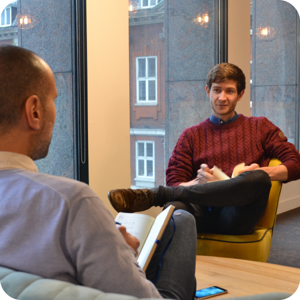 Two male recruiters sitting on lounge chair having conversation